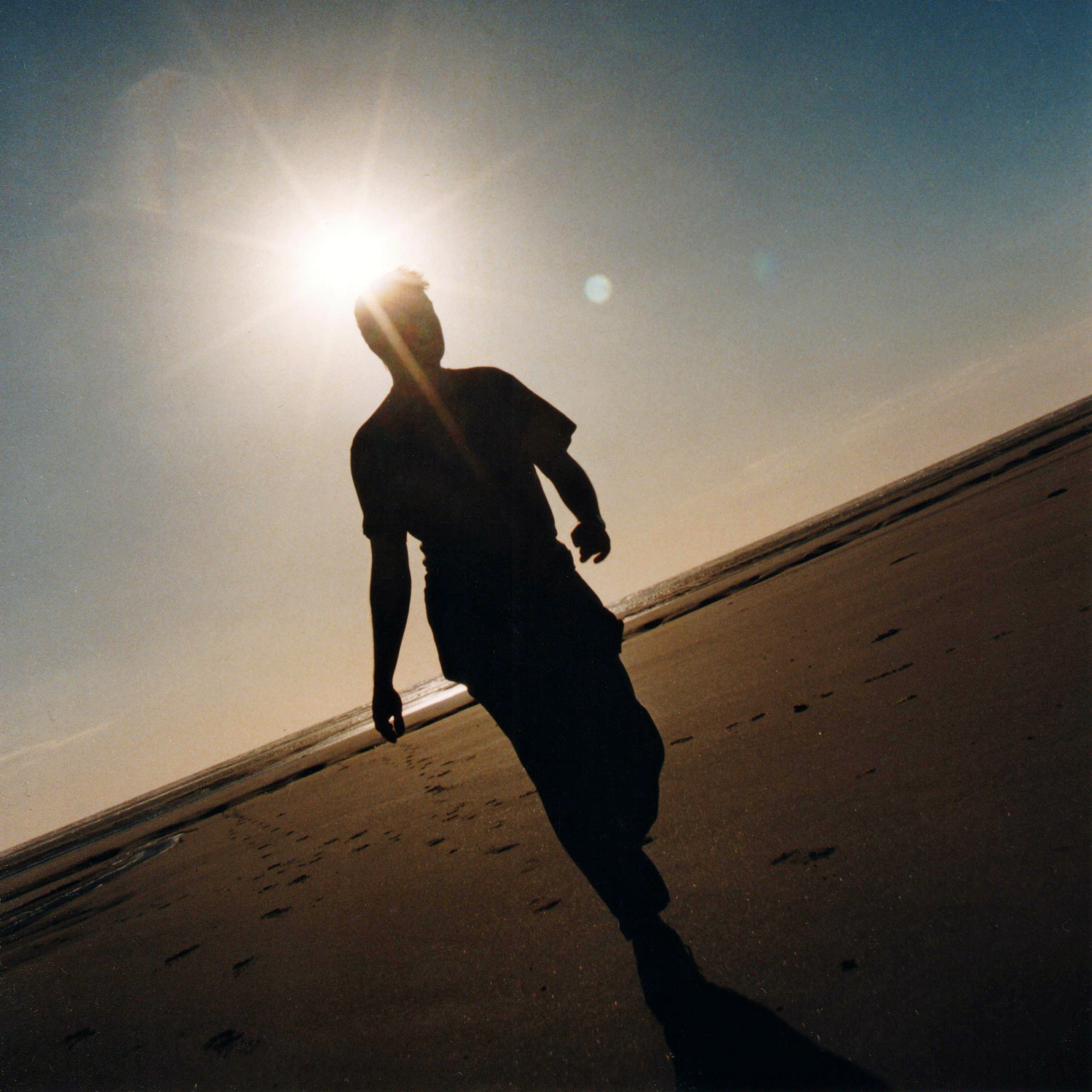 Silhouette de l'auteur en contre-jour sur une plage au soleil couchant